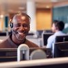 Portrait Of Mature Businessman Wearing Telephone Headset Working In Customer Services Department Portrait Of Mature Businessman Wearing Telephone Headset Working In Customer Services Department